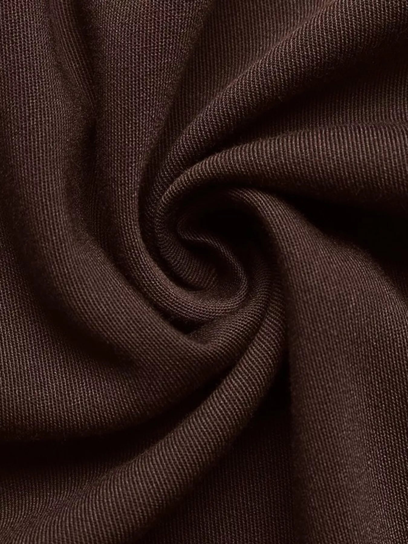 Bottom hem detail of the flowing brown V-neck long sleeve A-line midi dress, highlighting its length.
