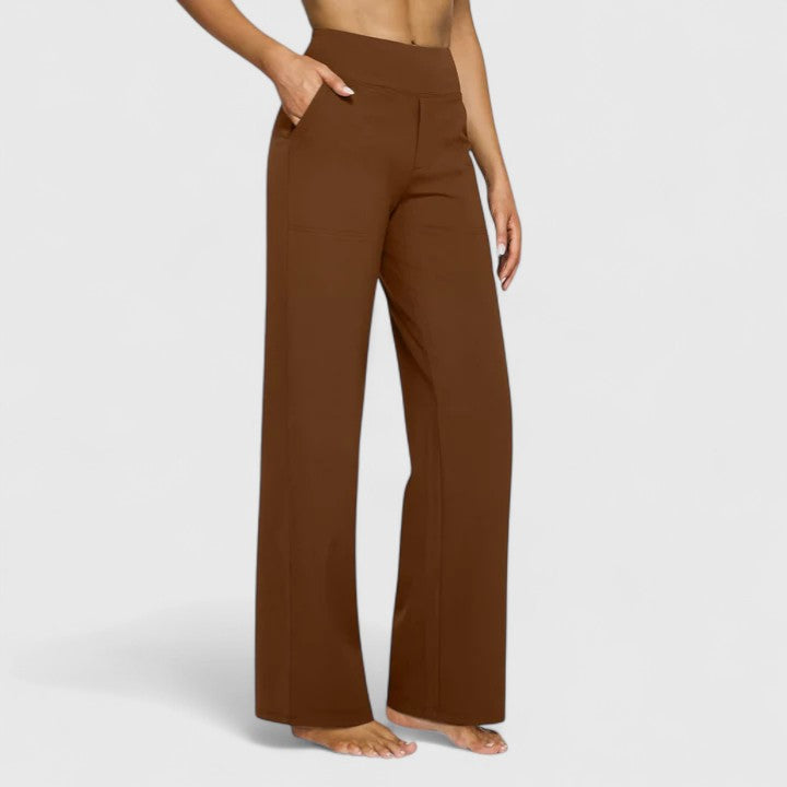 Woman sitting comfortably in red Adeline pull-on trousers, illustrating flexibility and ease of movement.