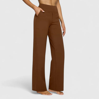 Woman sitting comfortably in red Adeline pull-on trousers, illustrating flexibility and ease of movement.