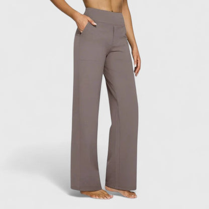 Lifestyle shot of a woman walking in grey Adeline pull-on trousers, showing their versatility for various activities.