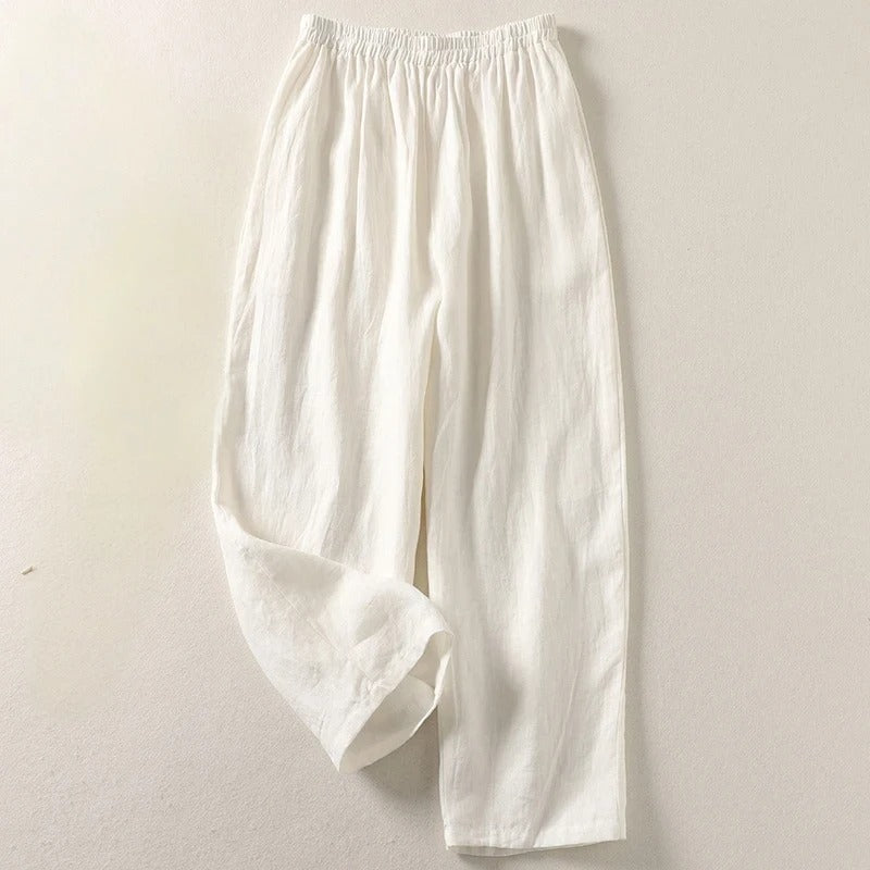 Model seated, comfortably showcasing the relaxed leg and elegant style of the Adira trousers.