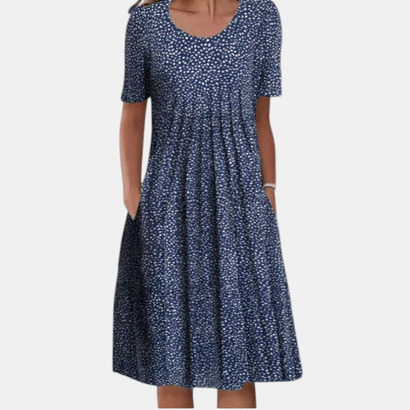 Lifestyle shot of a woman enjoying a casual outdoor setting while wearing the Alessia cotton tummy control dress in blue dots.