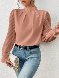The white ruffled mock neck blouse paired with smart trousers, ideal for a professional look.