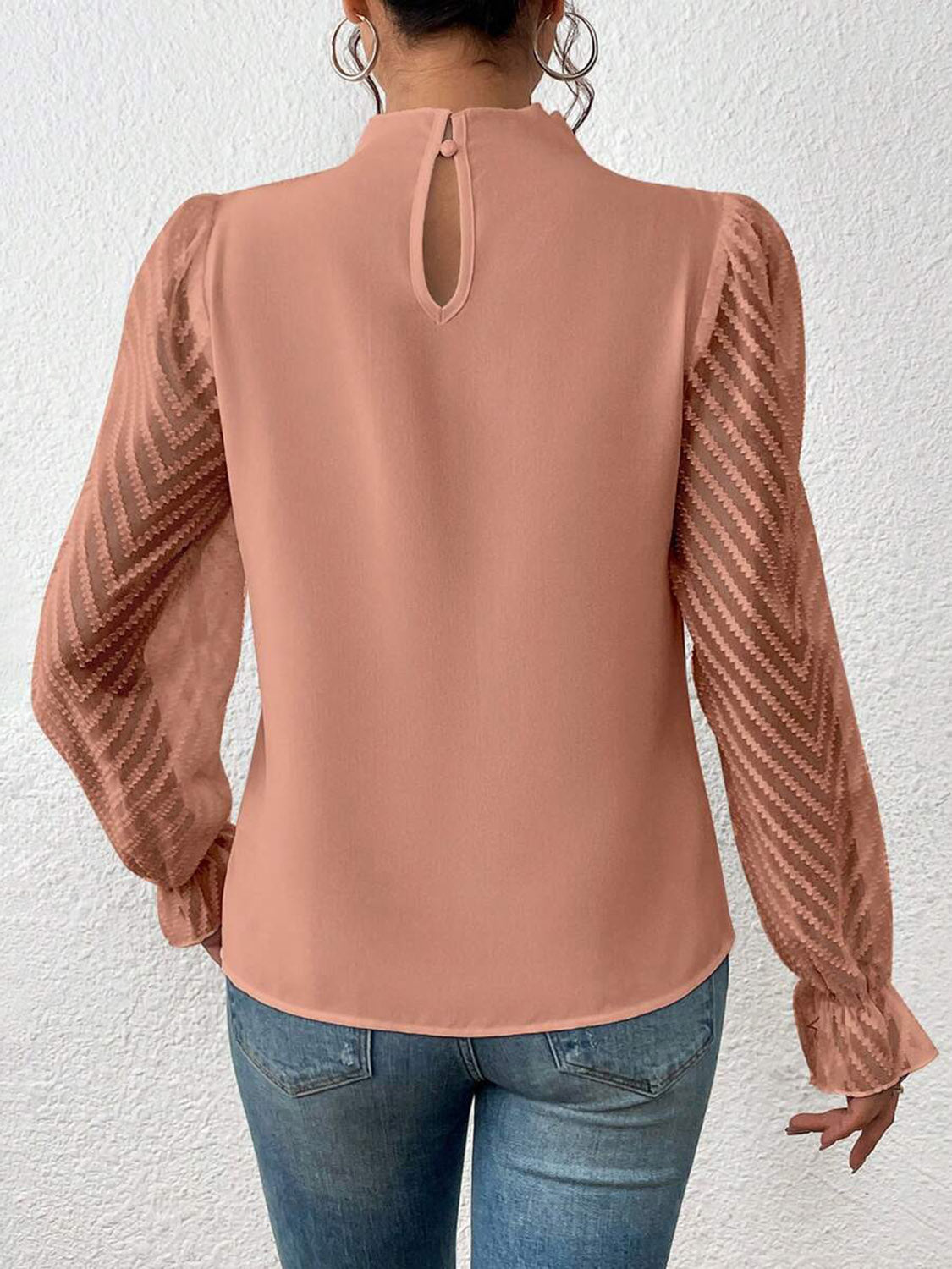 Detail of the mock neck closure on the cream ruffled mock neck blouse, focusing on the refined finish.