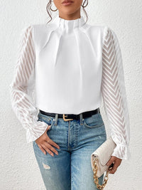 Stylised shot of the navy ruffled mock neck blouse, draped elegantly to highlight its versatility.