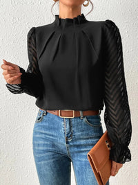 Model wearing the burnt coral ruffled mock neck blouse in a casual setting, demonstrating its relaxed fit.
