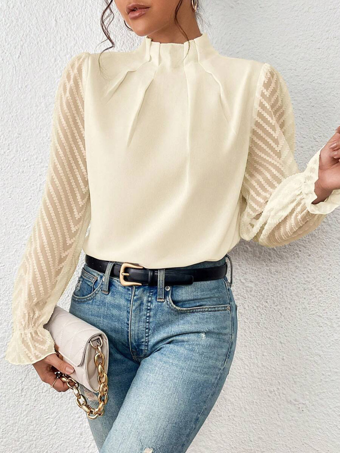 Close-up of the fabric texture on the black ruffled mock neck blouse, illustrating its semi-sheer quality.