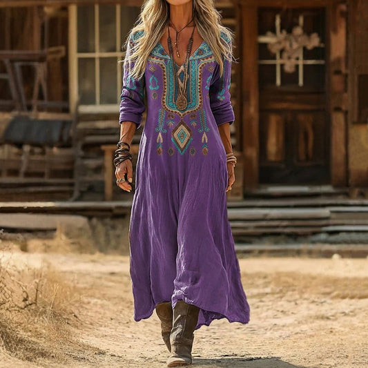 Front view of a woman wearing the purple Anthea vintage long sleeve dress, showcasing the flowing calf-length design and V-neck.