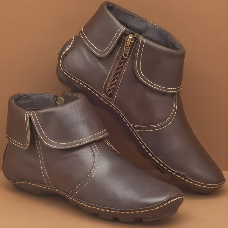 A woman wearing brown Audra orthopaedic waterproof boots, walking outdoors on a paved path, highlighting their practical style.
