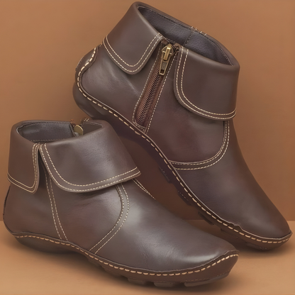 A woman wearing brown Audra orthopaedic waterproof boots, walking outdoors on a paved path, highlighting their practical style.