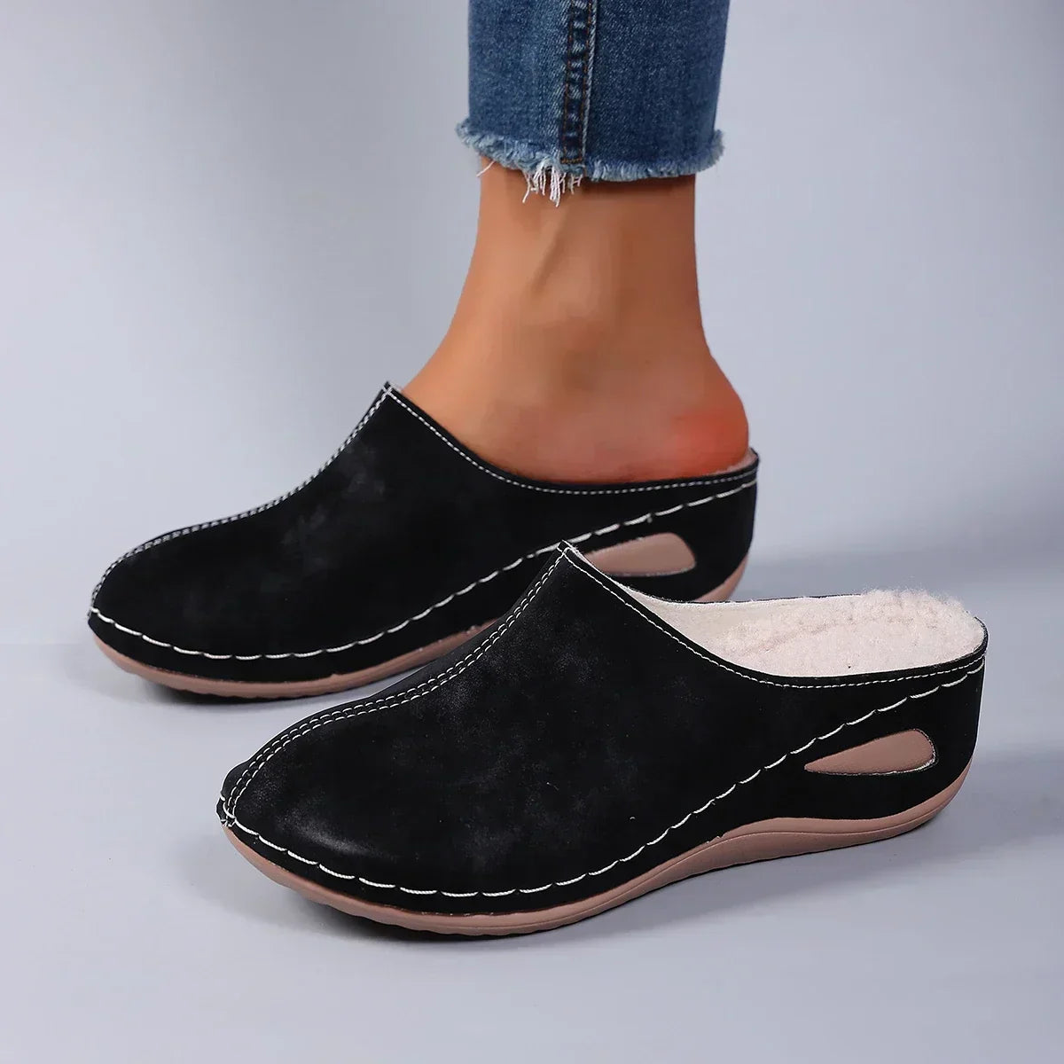 Model wearing brown Seraphina orthopaedic comfort slippers while standing on a wooden floor, full body shot.