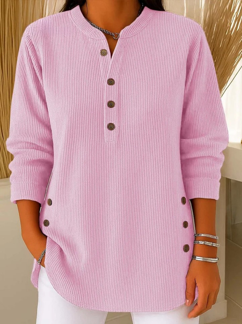 Front view of a woman wearing the dark blue Bronte ribbed long sleeve top, styled casually.
