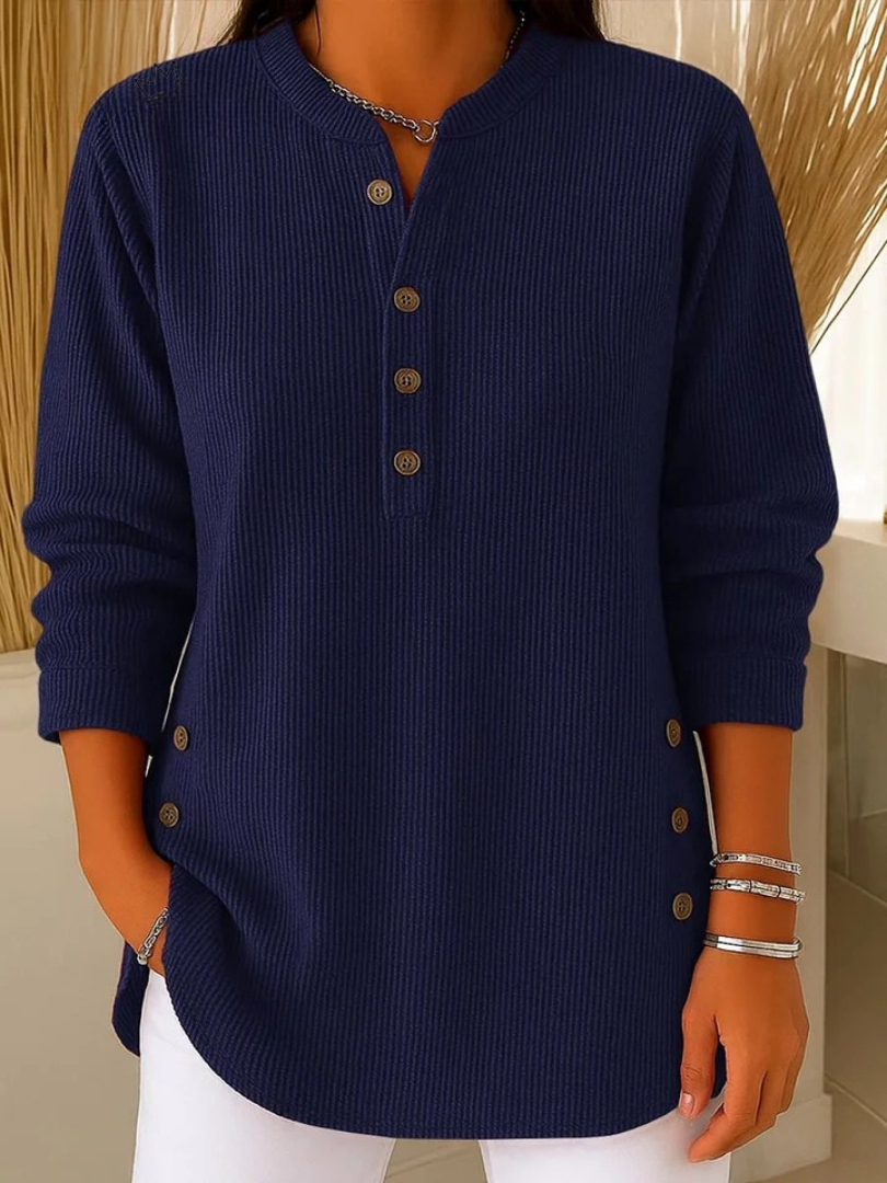 Side profile of a woman showcasing the relaxed fit and curved hem of the black Bronte ribbed long sleeve top.