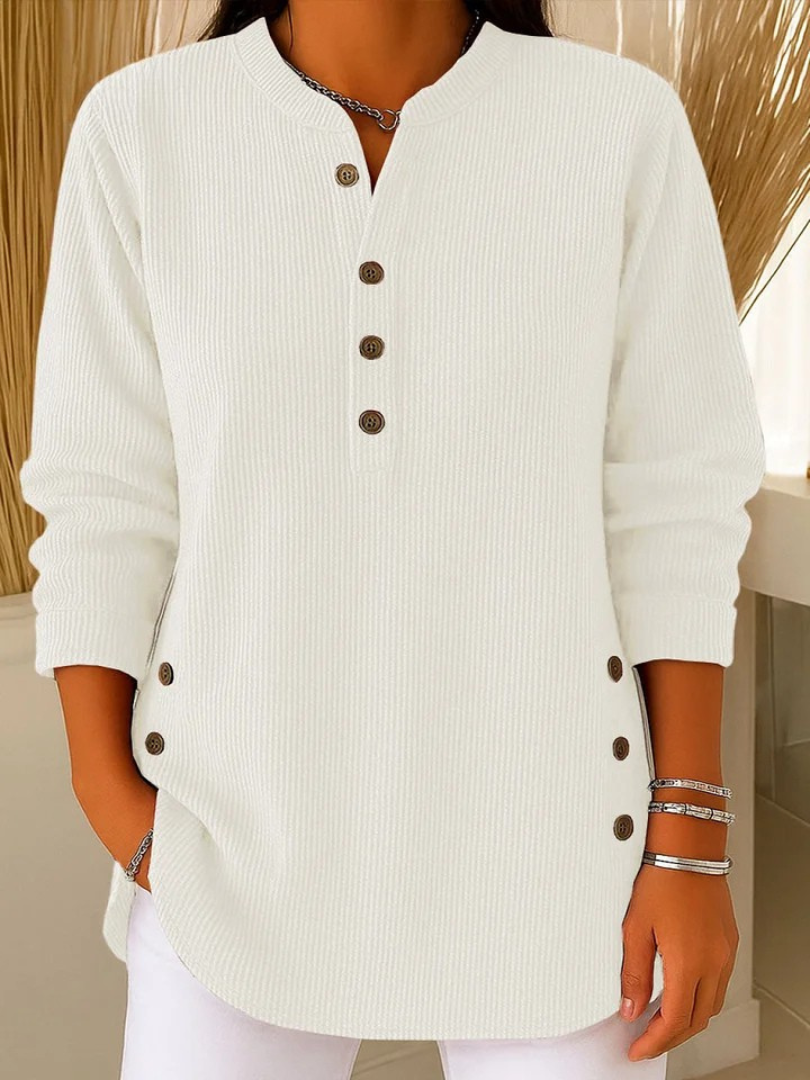 A woman smiling while wearing the green Bronte ribbed long sleeve top, demonstrating its comfort.