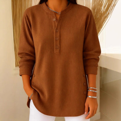 Lifestyle image of a woman pairing the pink Bronte ribbed long sleeve top with jeans for a casual look.