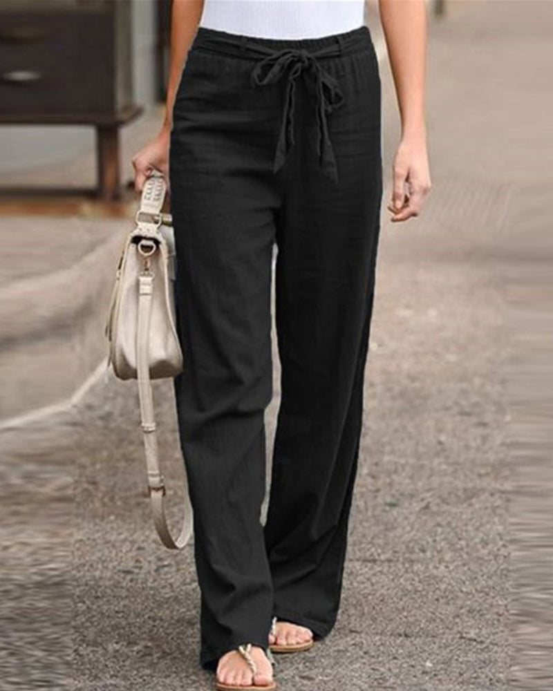 Side profile of a model wearing the Calla straight-leg trousers, highlighting the comfortable mid-waist fit.