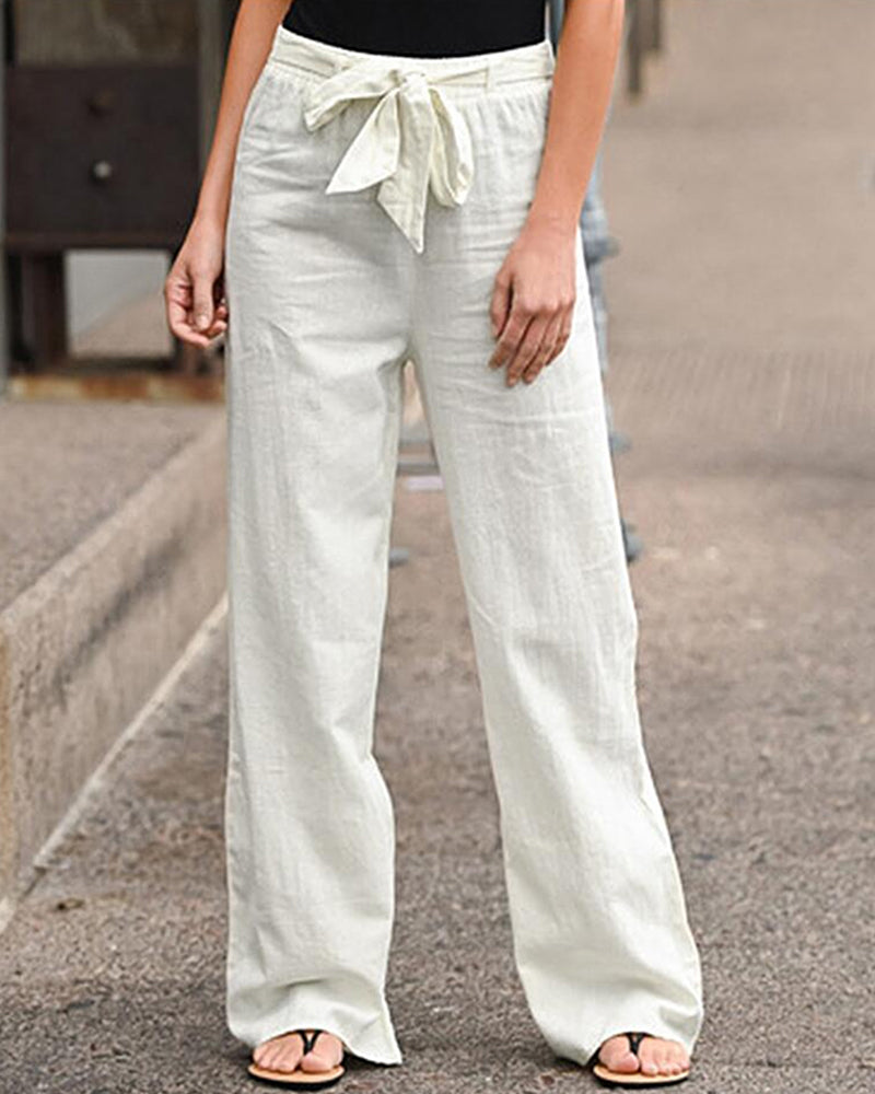 Close-up detail of the lace-up waist and texture of the Calla relaxed trousers, in a crisp white shade.