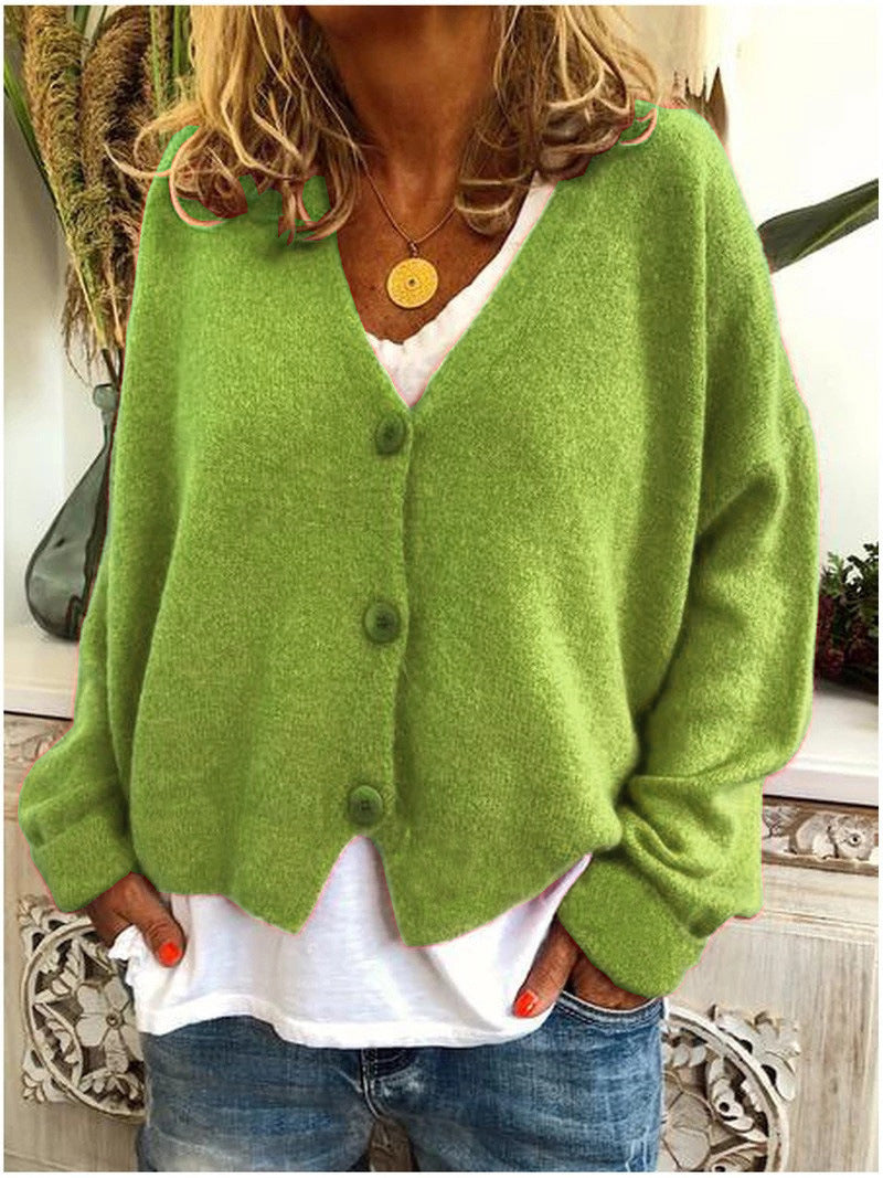 Model from the back wearing a blue Calypso V-neck button cardigan, showing the garment's fit and movement.