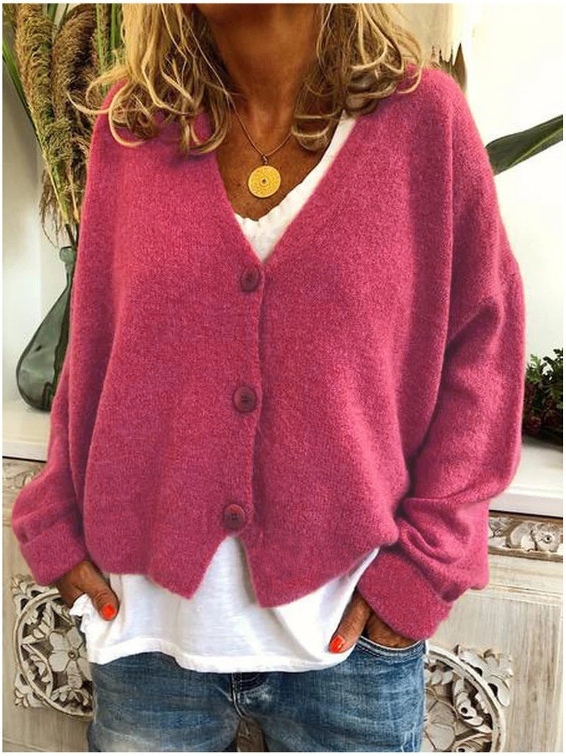 Model wearing a dark pink Calypso V-neck button cardigan, paired with jeans for a smart-casual look.
