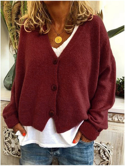 Close-up of the knit surface on a dark red Calypso cardigan, highlighting the quality and softness of the fabric.