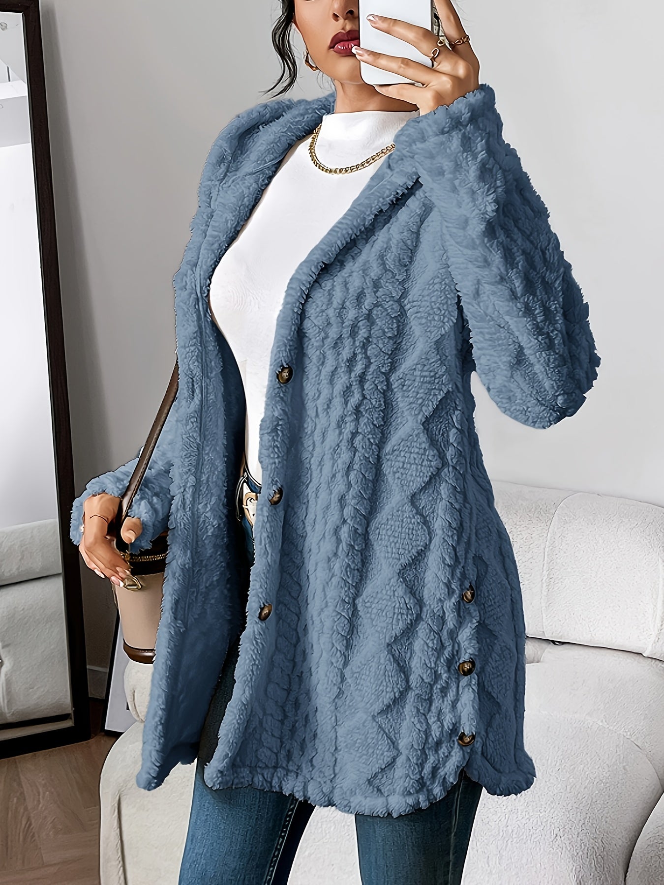 Close-up detail of the brown hooded knitted cardigan's irregular textured pattern and soft knit fabric.