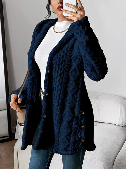 Front view of the blue grey hooded knitted cardigan on a hanger, displaying its full form and texture.