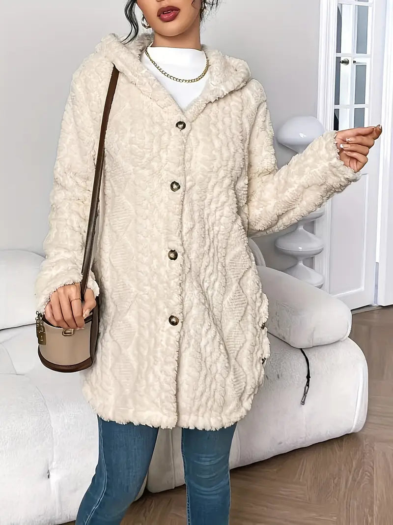 Lifestyle image of a woman enjoying a coffee while wearing the hooded knitted cardigan, looking comfortable.
