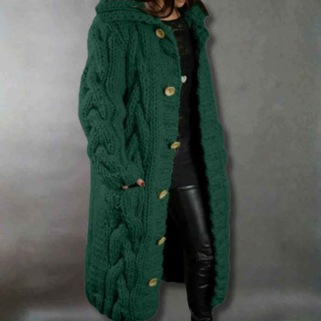 Front view of a woman wearing the Clara premium cable knit longline coat in a neutral colour, stylishly layered.