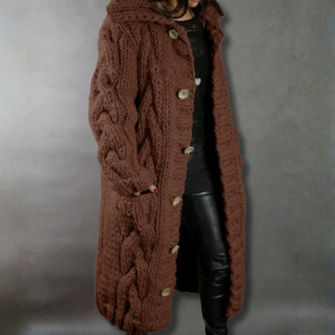 Side profile of the woman showcasing the relaxed fit and length of the cable knit longline coat, outdoors.