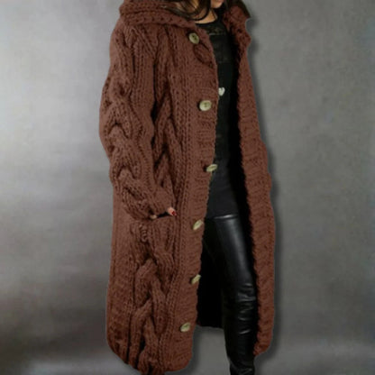 Side profile of the woman showcasing the relaxed fit and length of the cable knit longline coat, outdoors.
