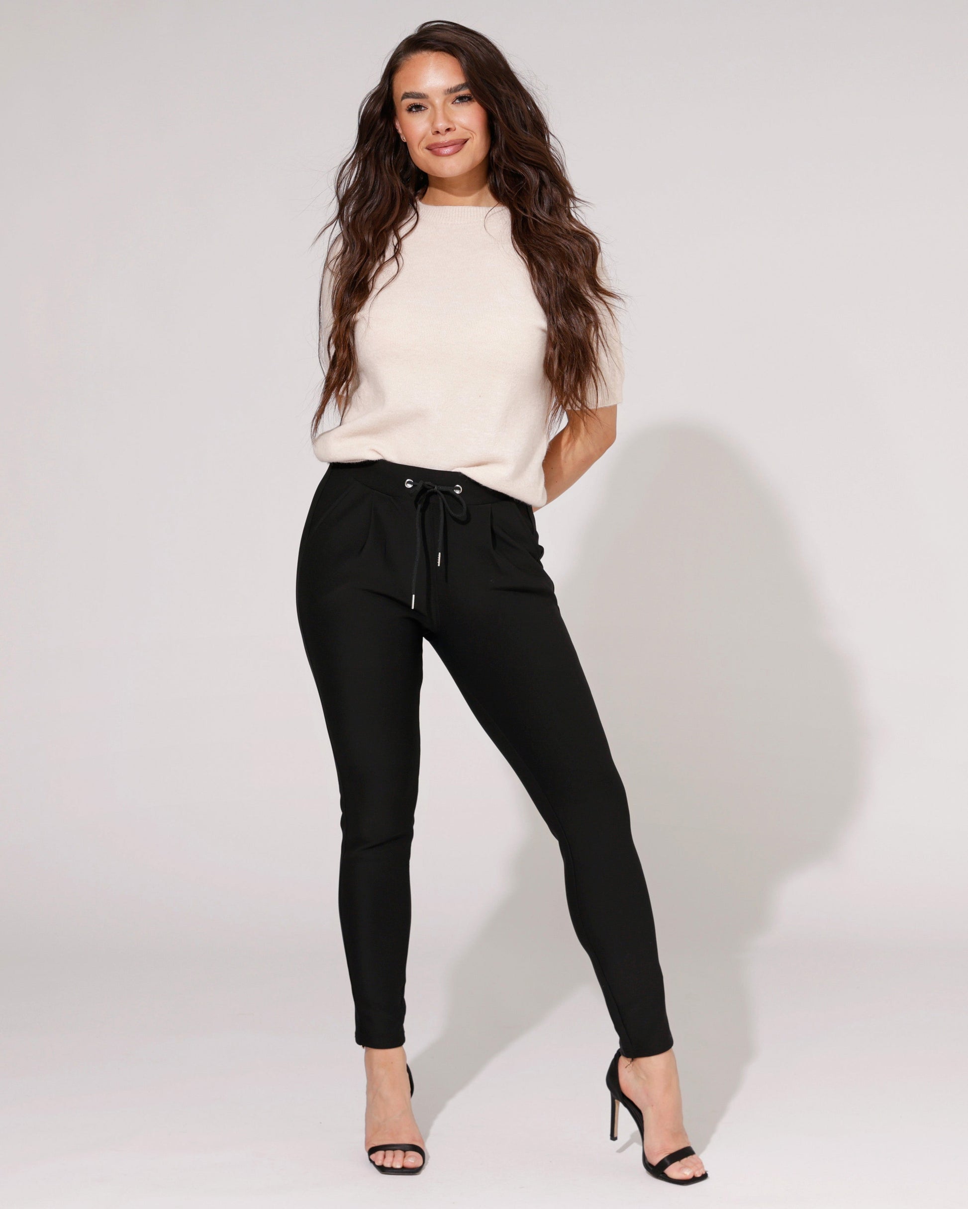 Side profile of a model wearing the black comfort skinny trousers, highlighting the flattering skinny fit.