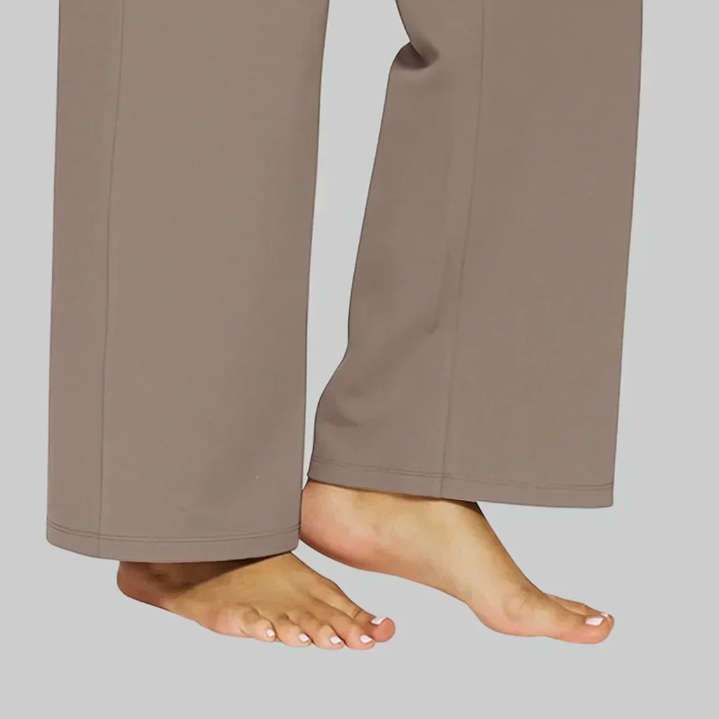 Woman sitting casually, highlighting the stretch and comfort of the taupe Clara trouser.