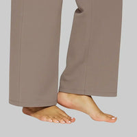 Woman sitting casually, highlighting the stretch and comfort of the taupe Clara trouser.