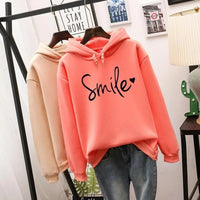 Side profile of a woman wearing the red-orange Cleo comfort hoodie, showcasing the relaxed fit.