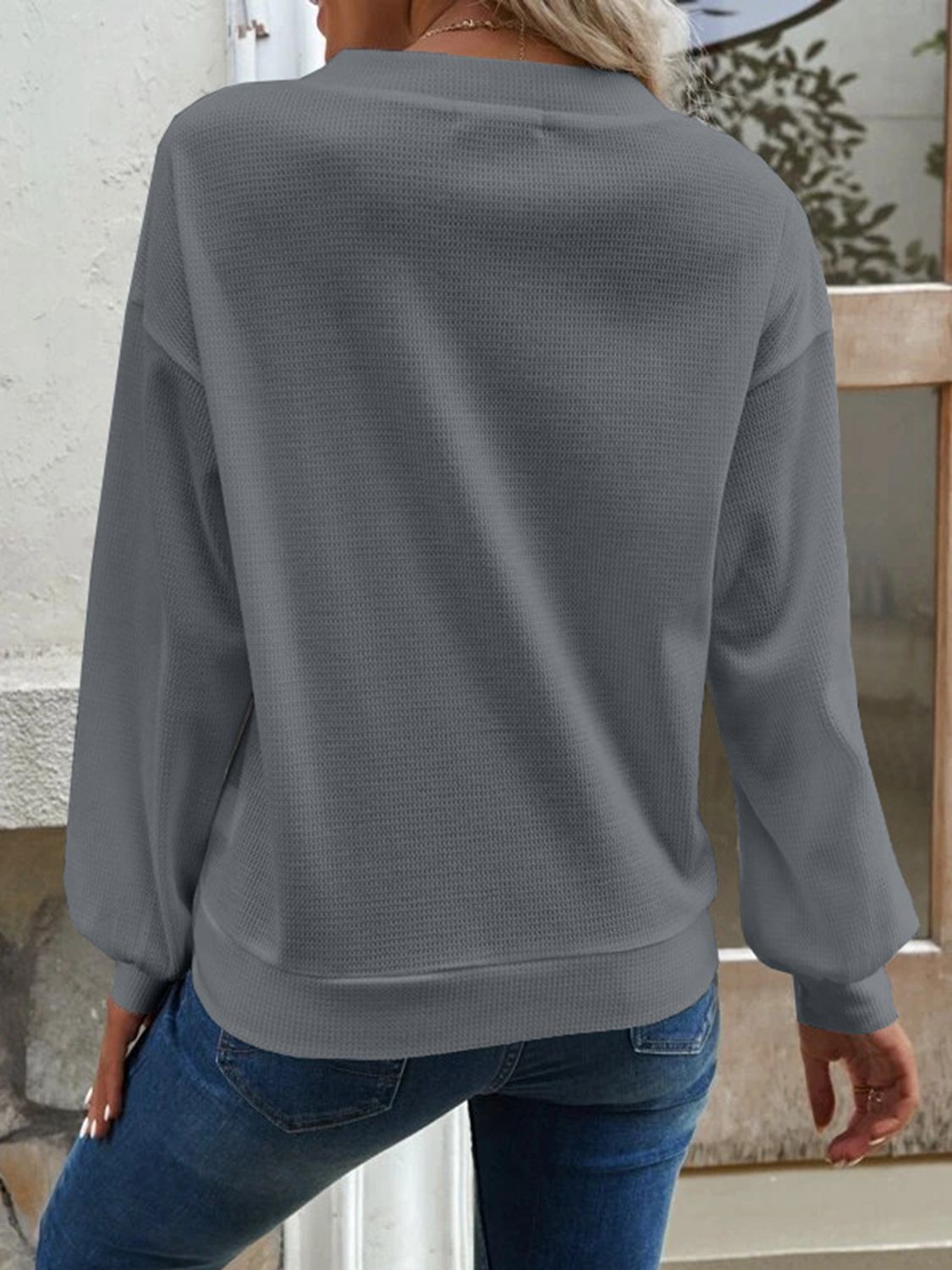 Side view of the dark grey Elowen blouse, showing the relaxed silhouette and comfortable design.
