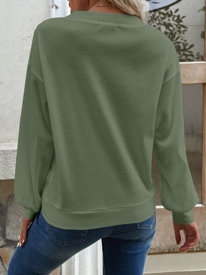 Detail of the matcha green Elowen blouse's V-neck, illustrating its clean and simple line.