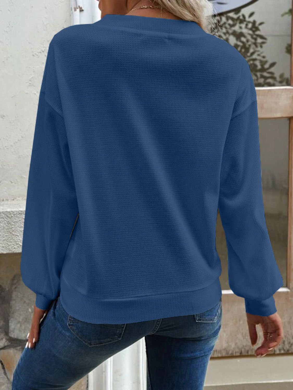 Detailed shot of the V-neckline on the blue Elowen blouse, emphasising its flattering cut.