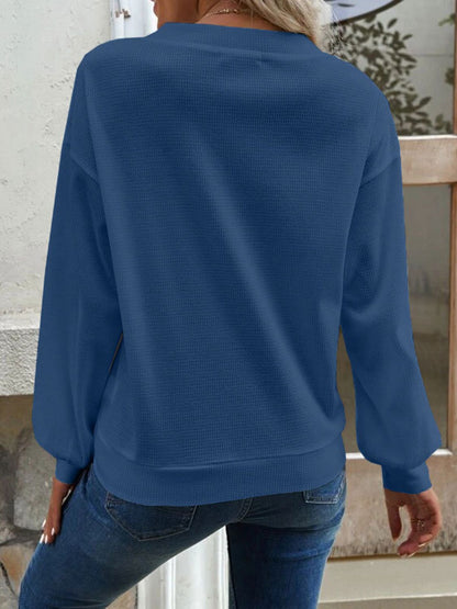 Detailed shot of the V-neckline on the blue Elowen blouse, emphasising its flattering cut.
