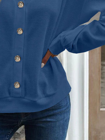 Close-up of the sleeve cuff on the blue waffle-knit blouse, showing the neat finishing.