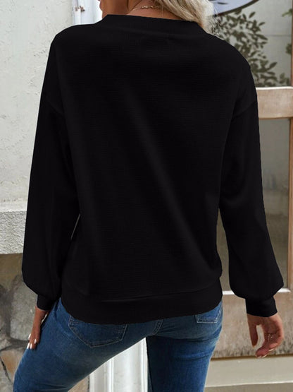 Model posing in the black Elowen blouse, demonstrating its comfortable drape and fit.