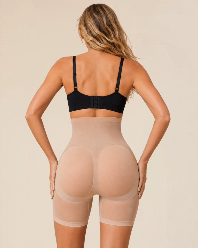 A model wearing the Estelle high-waisted seamless shaping shorts under a fitted dress, illustrating their invisible effect.