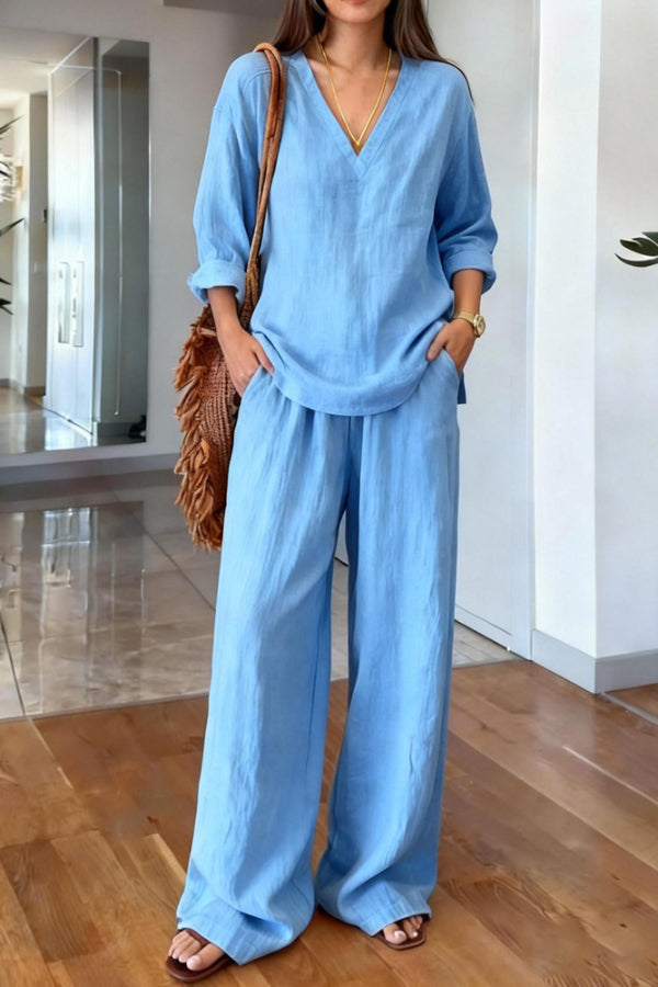A person wearing the blue Genevieve linen blend co-ord set, sitting casually outdoors, illustrating its vacation-ready style.