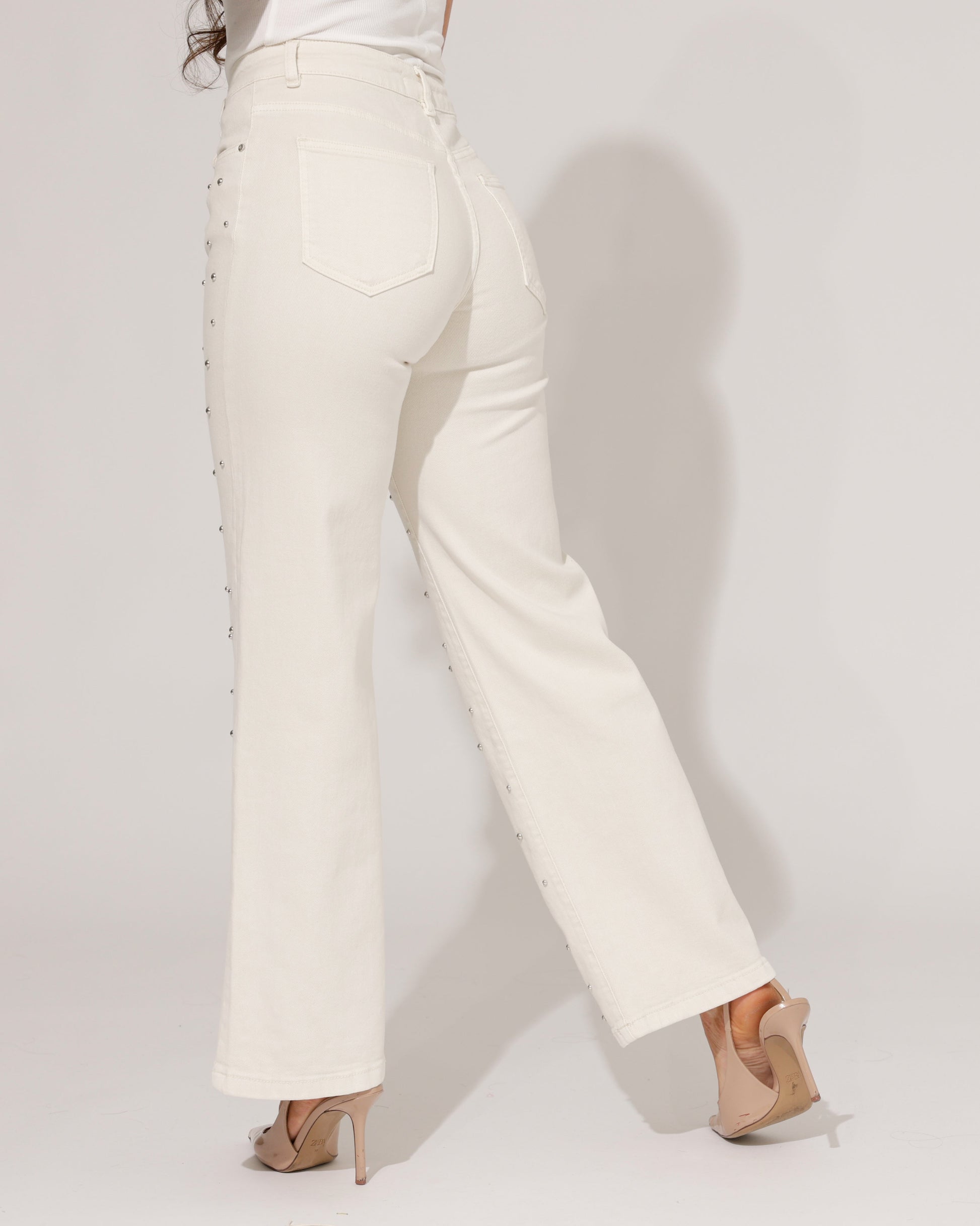 Side profile of a model wearing the Inara studded wide-leg jeans, demonstrating the flattering high-waist and flowy silhouette.