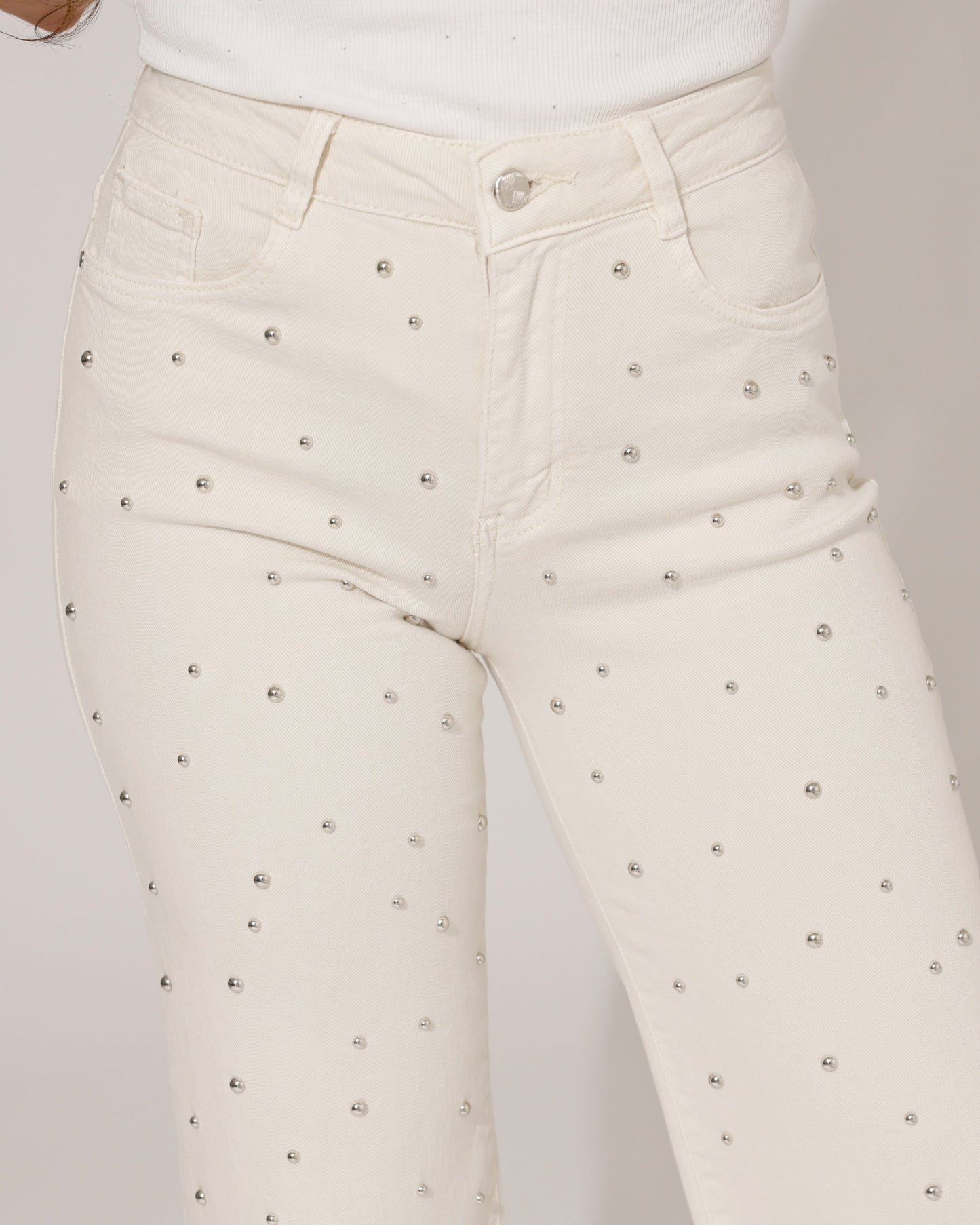 Detail shot of the waistband and button closure of the Inara beige wide-leg jeans, with a subtle brand tag visible.