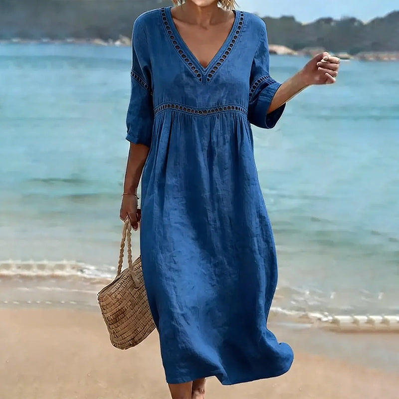 Detail of the fabric texture and embroidered pattern on the sleeve of the Inès mid-calf dress, emphasizing its quality.