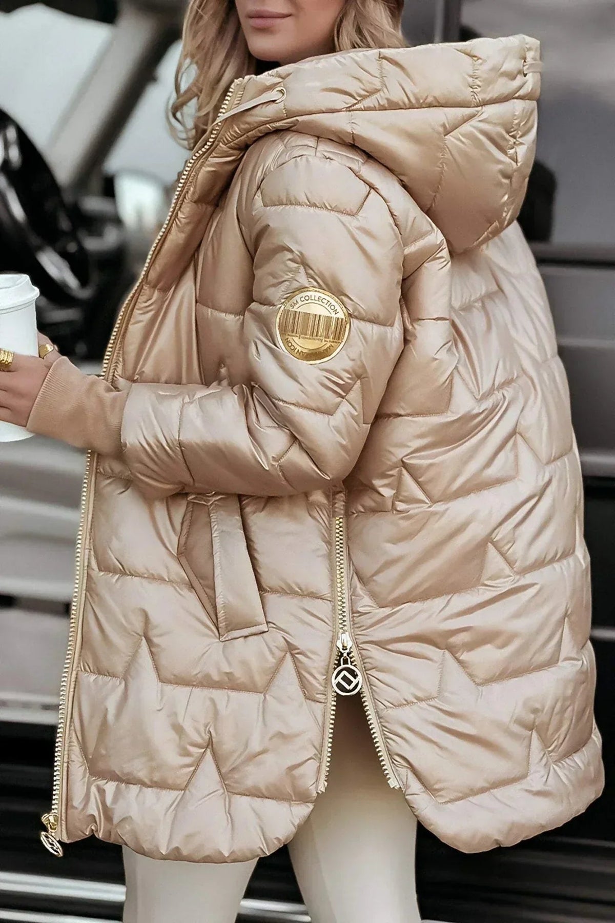 Detail shot of the zipper and side pocket on the Inez hooded winter jacket in beige.