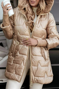 A woman wearing the grey Inez hooded winter jacket, walking outdoors in a natural setting.
