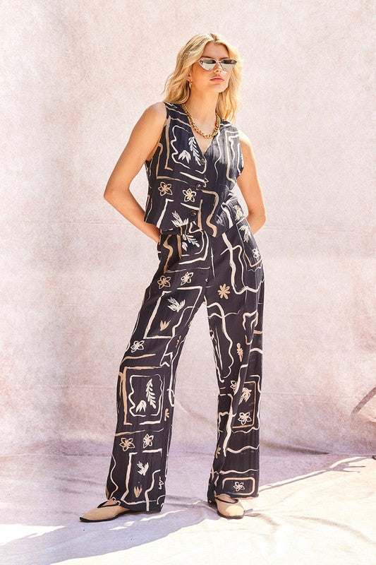Close-up of the pleated waist and button detail on the stylish wide-leg trousers.