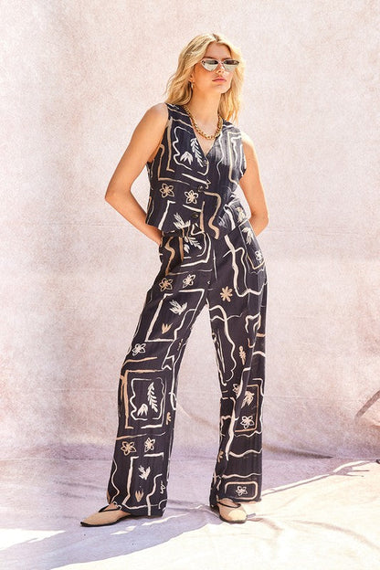 Close-up of the pleated waist and button detail on the stylish wide-leg trousers.