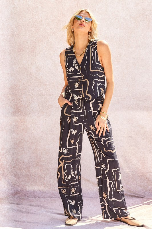 Side profile of the model wearing the patterned wide-leg trousers, highlighting the fabric drape.